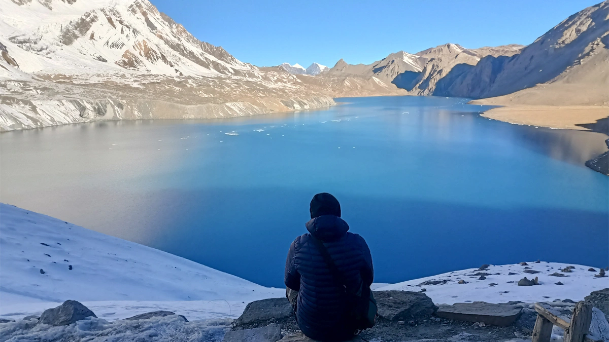 Trekker resting beside Tilicho Lake during Annapurna Circuit trek