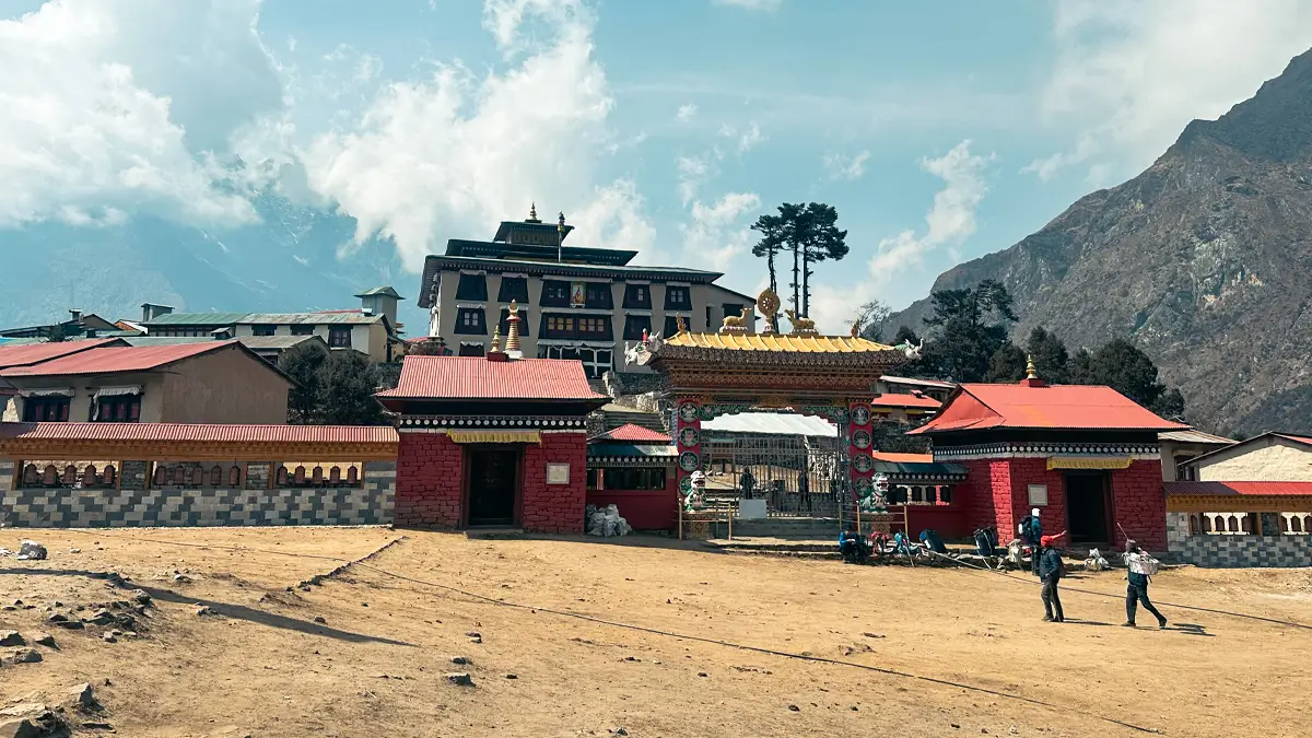 Tengboche Monastery in the Himalayas with snow-capped mountain backdrop.