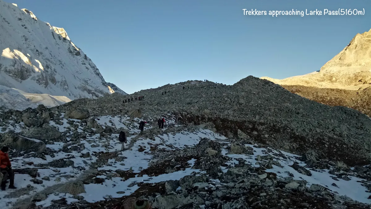 Trekkers slowly approaching the snowy trail leading to Larke Pass