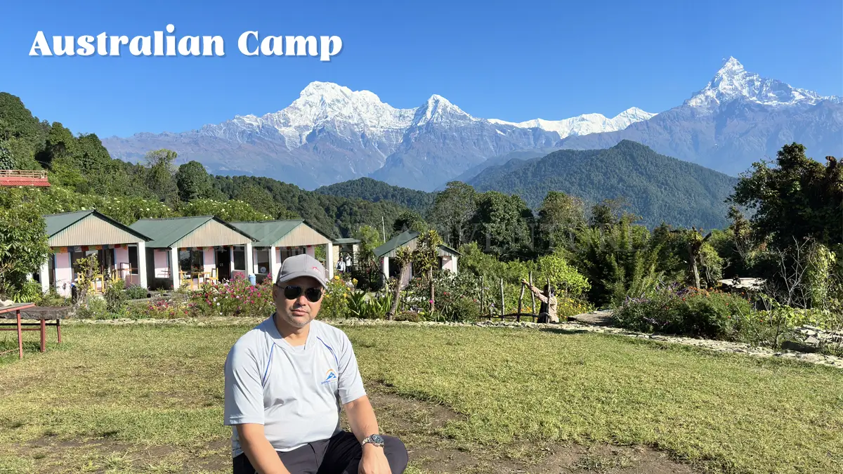 Scenic view of the Annapurna and Machapuchare mountains from Australian Camp surrounded by green hills.