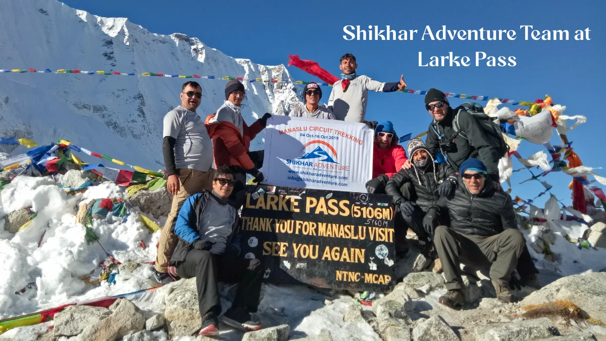 Trekking group crossing Larkya Pass on Manaslu Circuit trek with licensed guide and support team