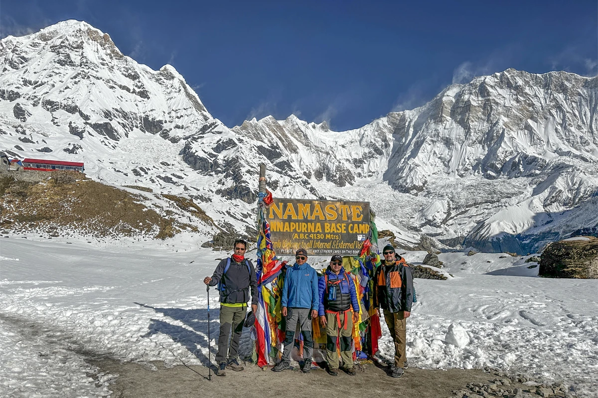 Teenage trekker with a guide on the trail to Annapurna Base Camp with snow peaks behind